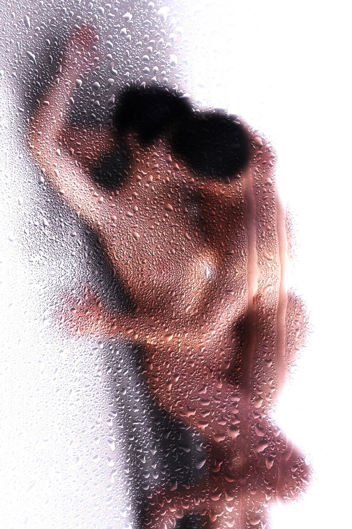 Nude figure seen through frosted, water-dropleted glass