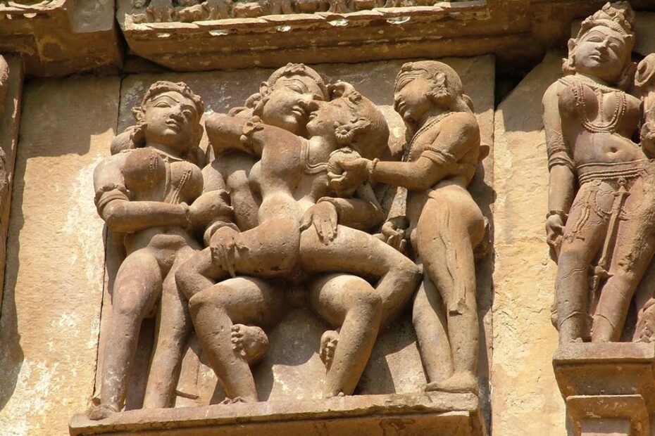 Ancient Khajuraho stone temple carving depicting erotic figures